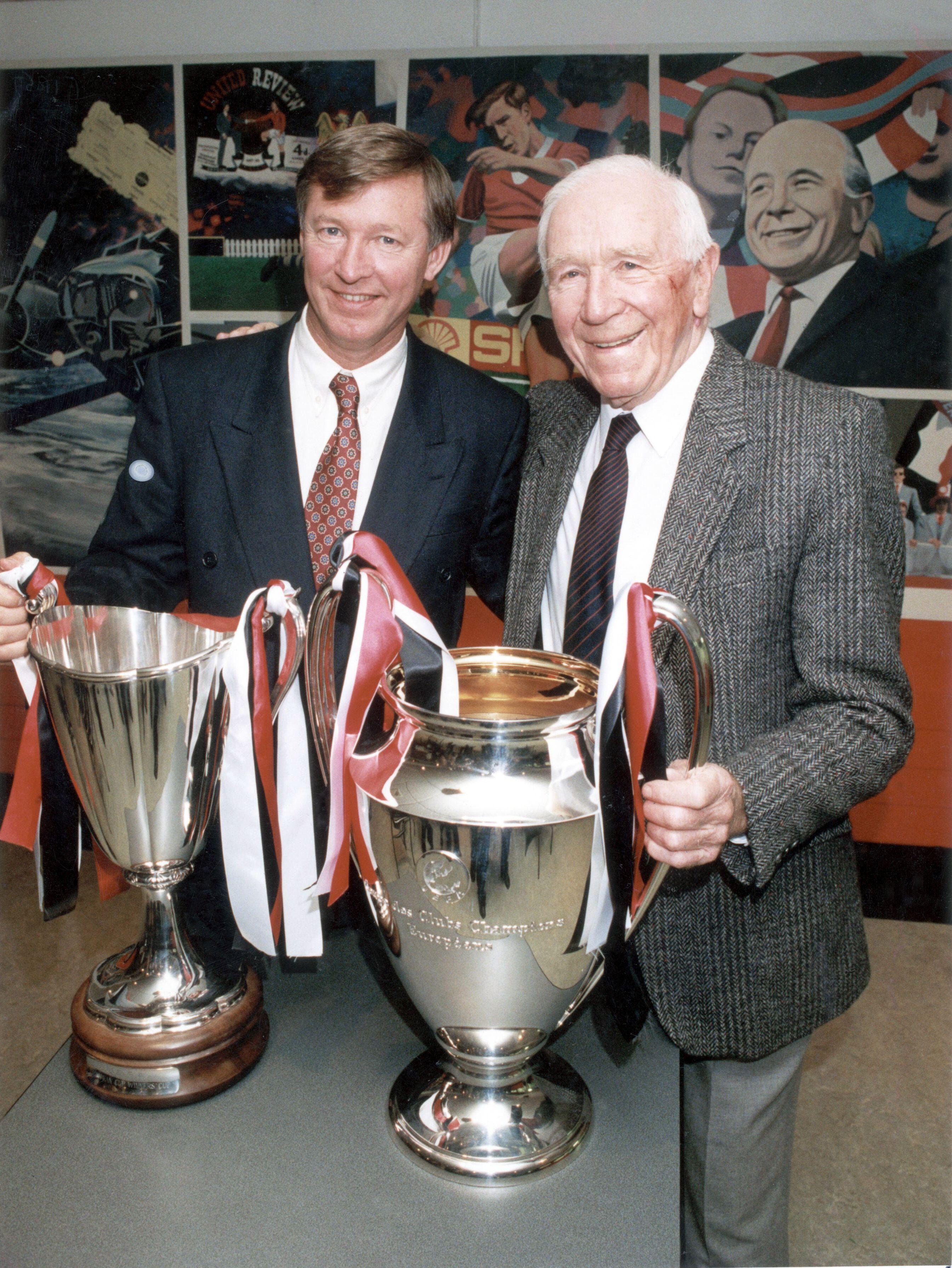 Sir Matt Busby and Sir Alex Ferguson together with the European Cup and league trophy
